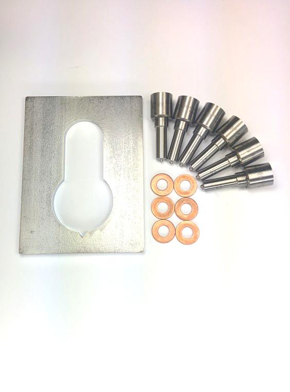 A set of Dynomite Diesel precision-engineered parts, including a large metal plate with a keyhole shape and several cylindrical metallic components arranged in a fan pattern, alongside small copper rings.